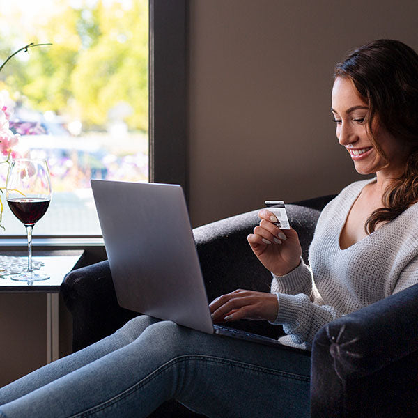 Woman purchasing wine online with credit card